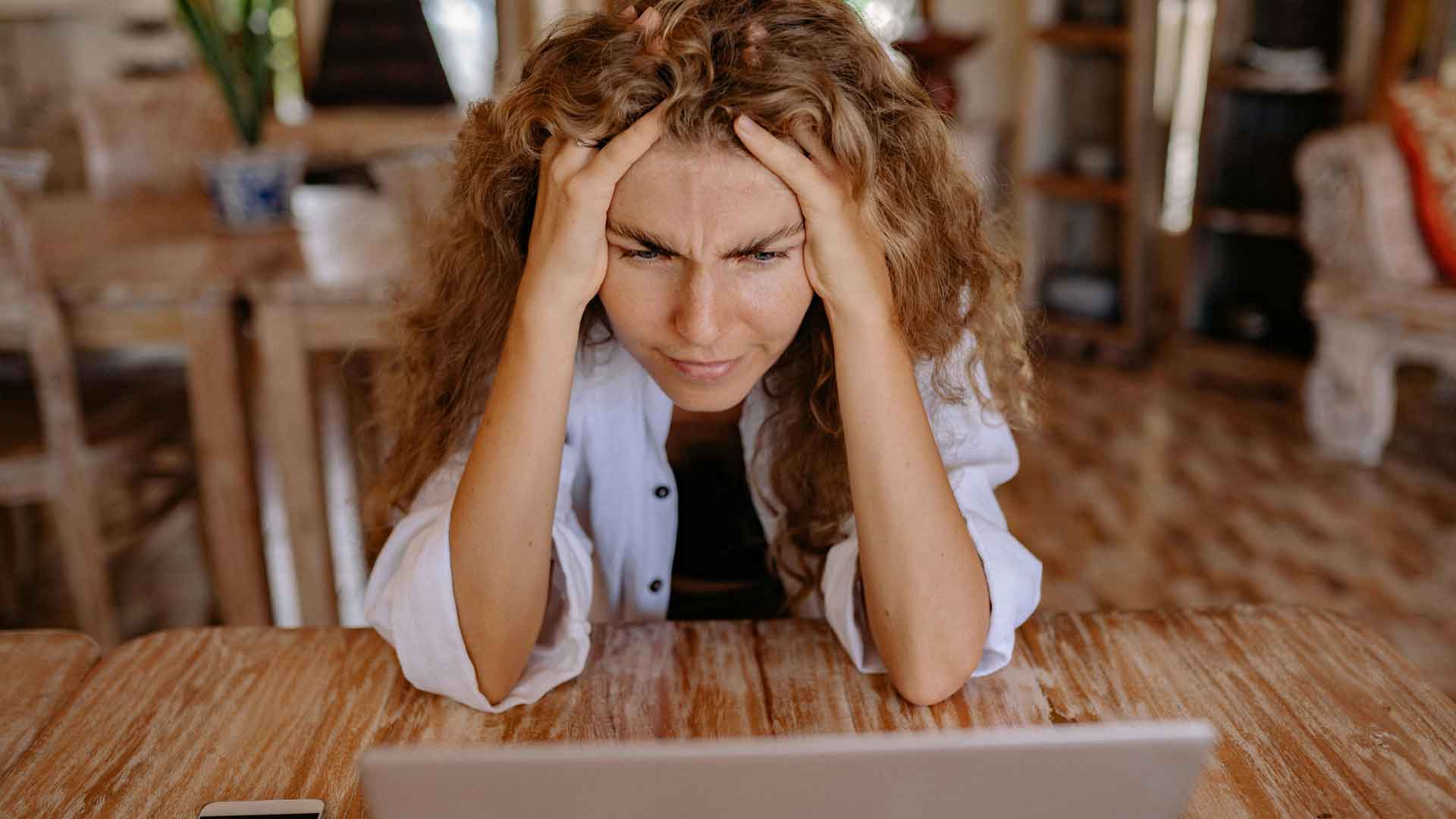 Bist du im richtigen Job? Frau grübelnd vor dem Computer